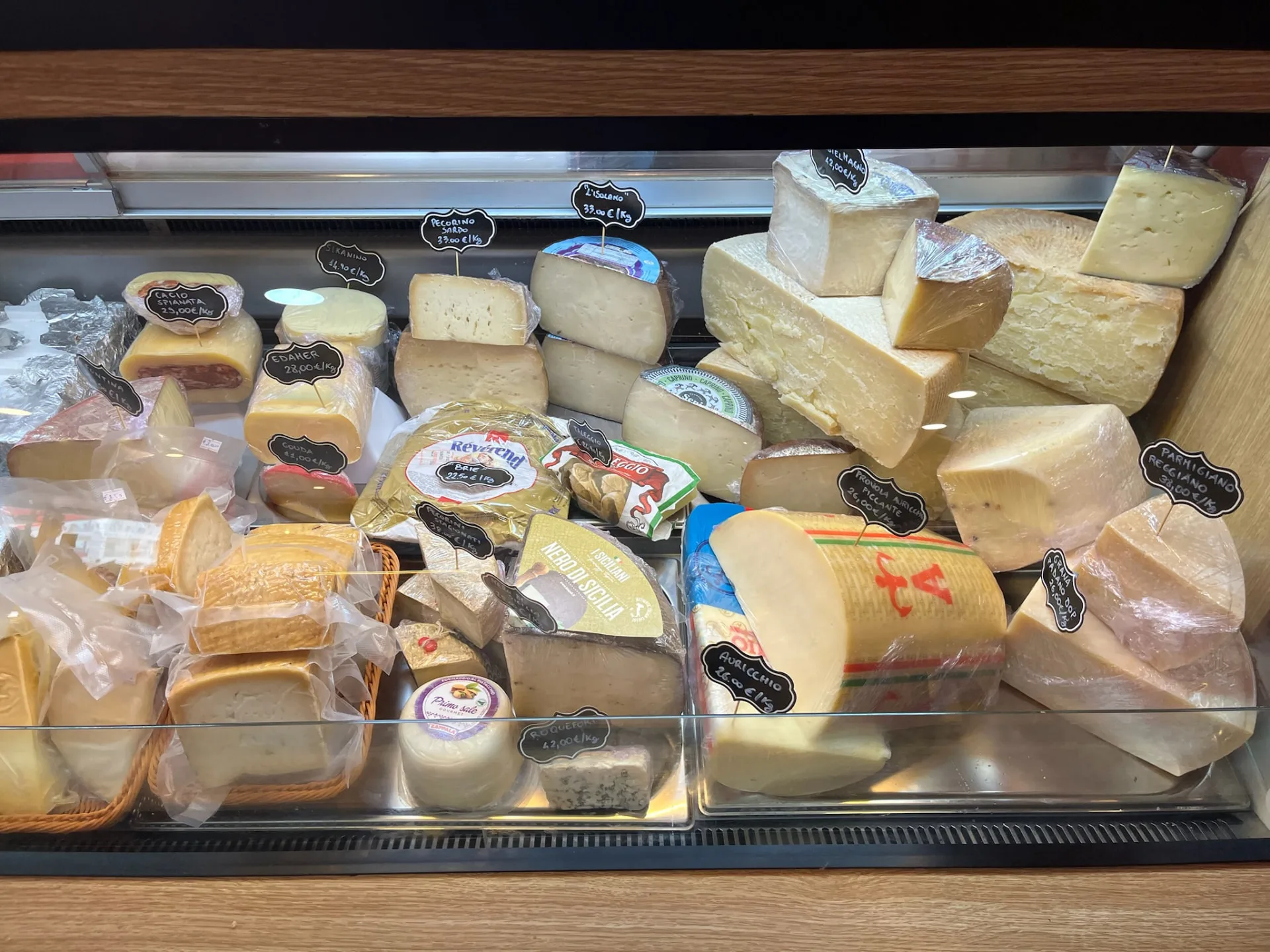Refrigerated display case of Italian cheeses at Origini Salumeria in Swieqi